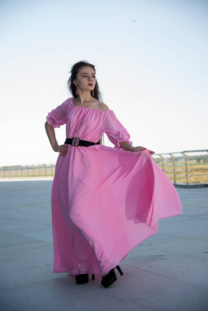 beautiful  young woman in pink dress posing on terrace  - Fotoğraf, Görsel