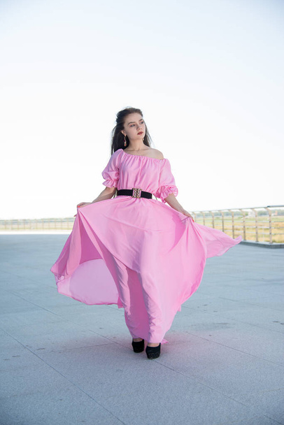 beautiful  young woman in pink dress posing on terrace  - Fotografie, Obrázek