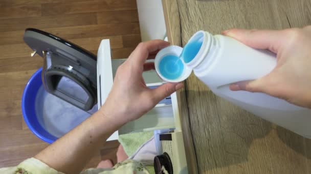 Mujer llenando una taza de plástico con detergente de lavandería - Metraje, vídeo