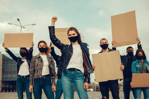 Een groep mensen met een masker die naar buiten kwamen met posters om te protesteren Het protest van de bevolking tegen het coronavirus en tegen de invoering van quarantainebijeenkomst over coronavirus en mensenrechten. Kopieerruimte - Foto, afbeelding