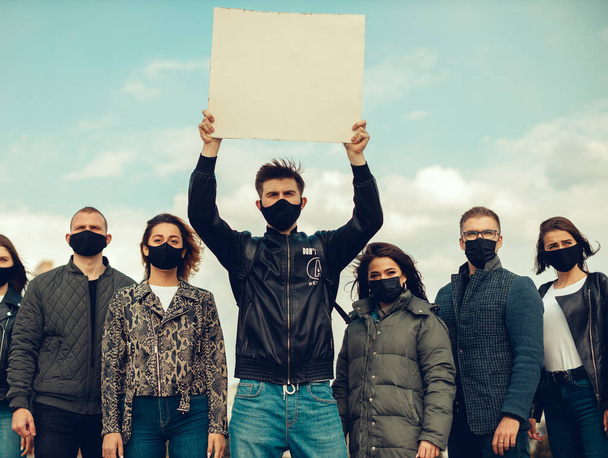 Koronavirüs karşıtı protestoları ve koronavirüs ve insan haklarıyla ilgili karantina toplantısını protesto etmek için posterlerle gelen maskeli bir grup insan. Kopyalama alanı - Fotoğraf, Görsel