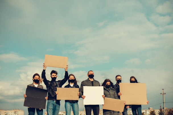 Skupina lidí s maskou, kteří vyšli s plakáty na protest Protest obyvatelstva proti koronaviru a proti zavedení karantény Setkání o koronaviru a lidských právech. Copyspace - Fotografie, Obrázek