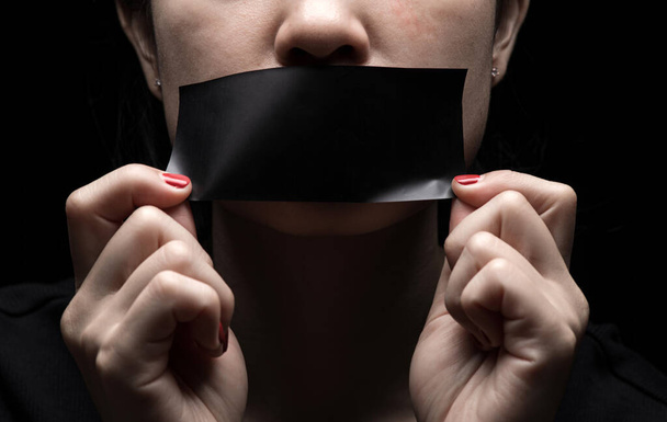 Koncepcja na temat wolności słowa, cenzury, wolności prasy. Międzynarodowy Dzień Praw Człowieka: twarz dziewczyny jest zapieczętowana czarnym papierem - Zdjęcie, obraz