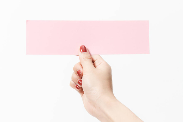 Fermer les femmes tenant du papier blanc rose sur fond blanc. Espace libre, prêt pour le type avec bannière texte
. - Photo, image