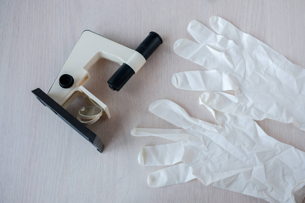 Still life : Microscope and disposable gloves on the table - Photo, image