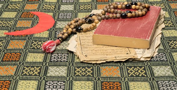 Perline di preghiera musulmana con Corano e con fogli con antichi scritti arabi. Concetti islamici e musulmani
 - Foto, immagini