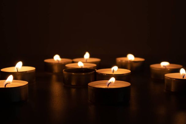 Religious and devoutness scene: candles burning in the dark - 写真・画像