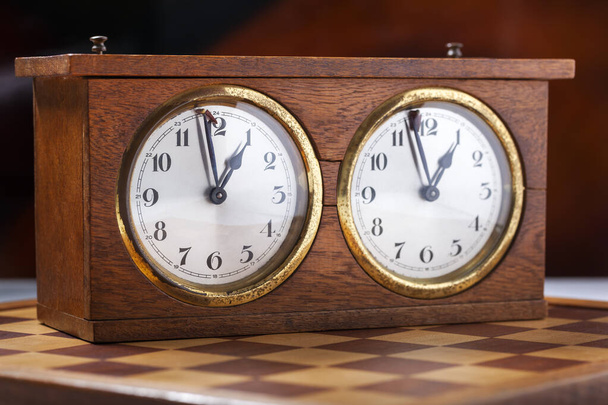 Velho relógio de xadrez vintage de madeira com e um tabuleiro de xadrez
  - Foto, Imagem