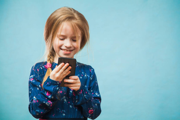 Happy preteen girl using smartphone, texting message. - Foto, Imagem