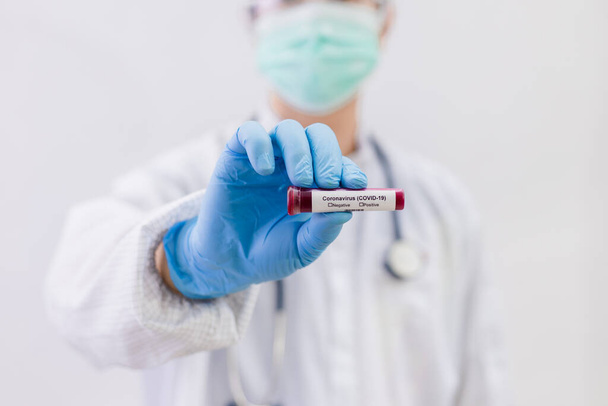 Лабораторне тестування зразків крові для присутності коронавірусу (COVID-19) Лікар проводить пробну трубку, що містить зразки крові, яка не має результату позитивного або негативного для коронавірусу
. - Фото, зображення