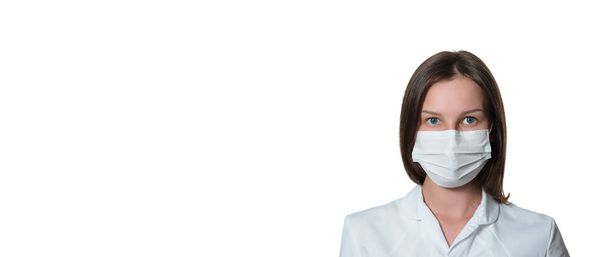 Mladá sestřička na kameře s chirurgickou nebo lékařskou maskou. Doktor v bílém plášti izolovaném na bílém pozadí. covid 19, coronavirus, karanténa, banner - Fotografie, Obrázek