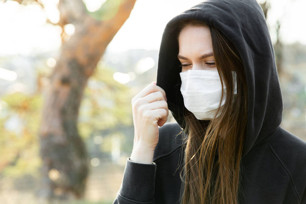 Mulher usando máscara facial durante o surto de coronavírus. Protecção contra a infecção pelo vírus - gases de escape e emissões industriais
 - Foto, Imagem