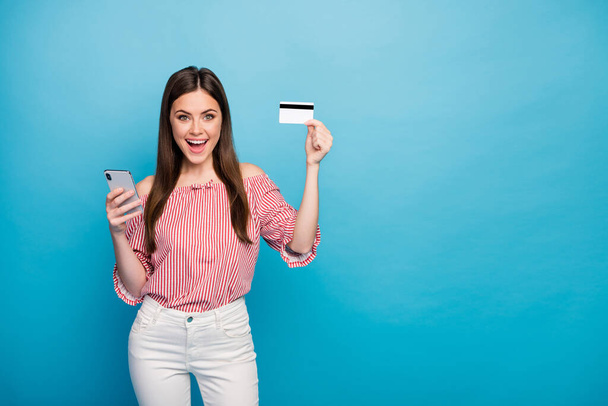Portrait of her she nice attractive lovely pretty fashionable cheerful cheery girl using cell bank card buying goods online isolated over bright vivid shine vibrant blue color background - Valokuva, kuva