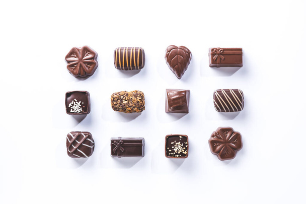різноманітність шоколадних пралінів, симетричних ізольованих на білому тлі. солодка і шоколадна концепція
. - Фото, зображення