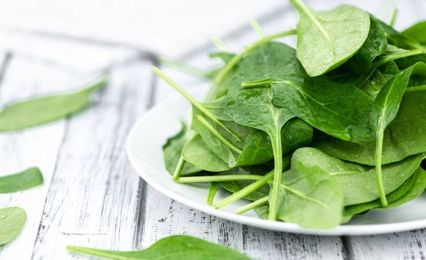 Vintage looking wooden table with fresh Spinach as detailed selective focus (close-up shot) - Fotoğraf, Görsel