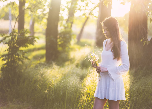 Woman wearing a white dress by trees - Photo, Image