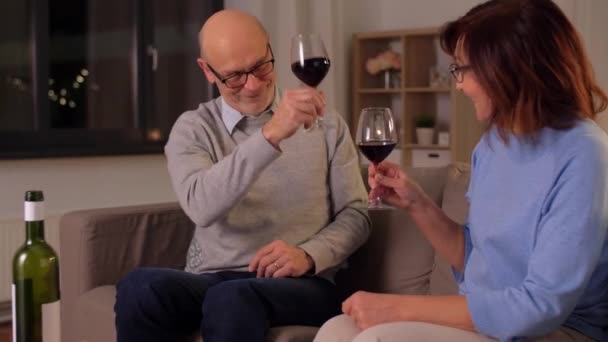 happy senior couple drinking red wine at home - Materiał filmowy, wideo