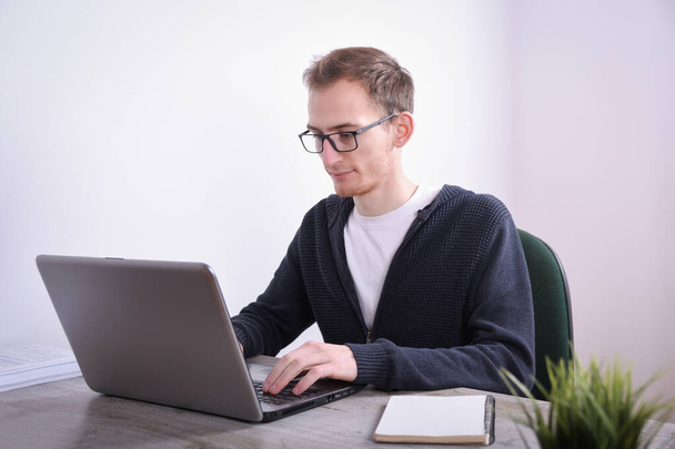 Портрет молодого бизнесмена, сидящего за рабочим столом технологии ноутбука в офисе. Интернет-маркетинг, финансы, бизнес-концепции v
 - Фото, изображение