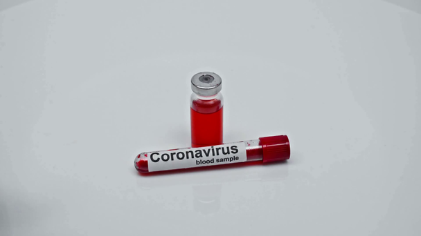 abgeschnittene Ansicht eines Wissenschaftlers, der Coronavirus-Impfstoff, Blutprobe und Spritze nimmt - Filmmaterial, Video