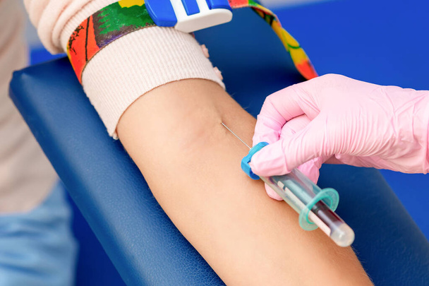 Enfermera mano está introduciendo la vacuna contra el coronavirus introduciendo una aguja en una vena del brazo de la mujer
. - Foto, imagen