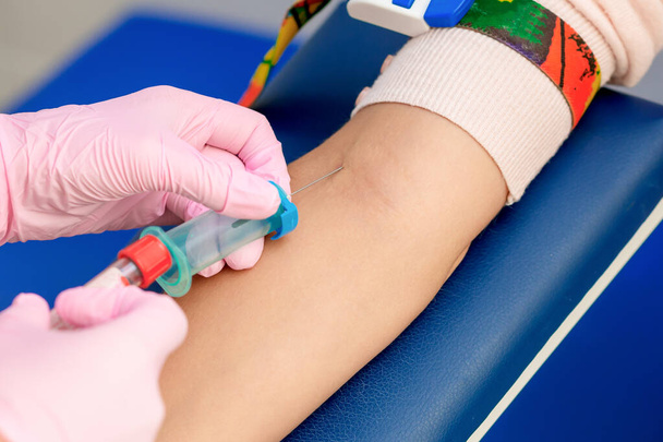 Enfermera introduciendo la vacuna contra el coronavirus introduciendo una aguja en una vena del brazo de la mujer
. - Foto, imagen