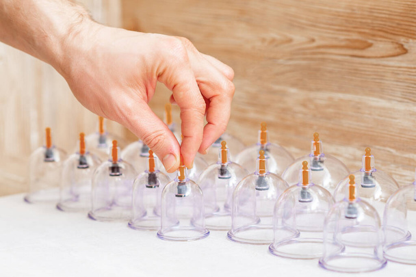 Ruční braní vakuové masážní sklenice z lékařské sady tradiční čínské cupping terapie. Cupping Therapy Set. - Fotografie, Obrázek
