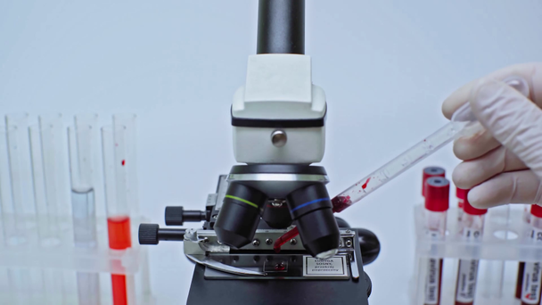 cropped view of scientist researching coronavirus blood sample on microscope - Footage, Video