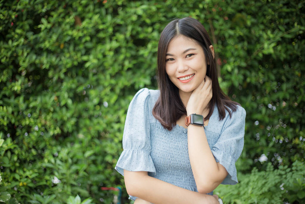 Fashion portret van mooie Aziatische vrouwen staan in de zomer park groene blad achtergrond - Foto, afbeelding