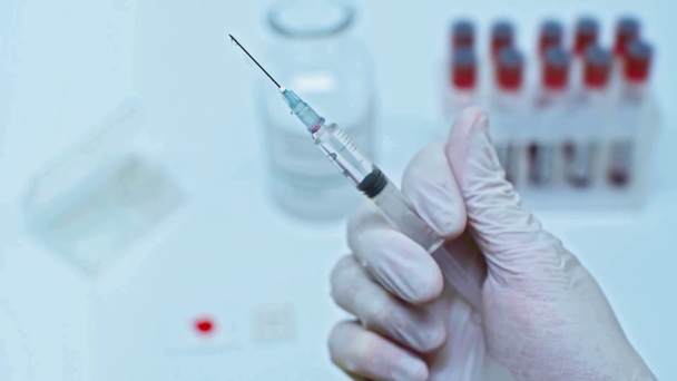 abgeschnittene Ansicht eines Wissenschaftlers, der Spritze mit Impfstoff in der Hand hält - Filmmaterial, Video