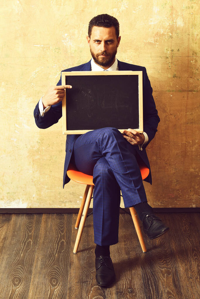 businessman or serious man holding a blackboard - Fotoğraf, Görsel
