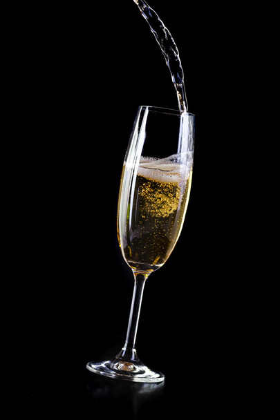 Champagne pouring in crystal glass, on black background - Valokuva, kuva