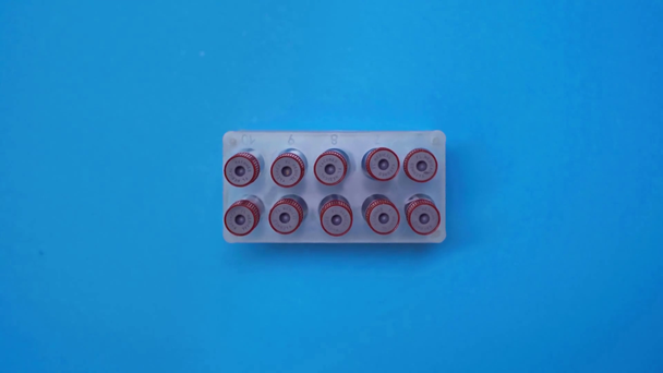 Horní pohled na spřádání zkumavky s krevními vzorky v stojanu na modrém pozadí - Záběry, video