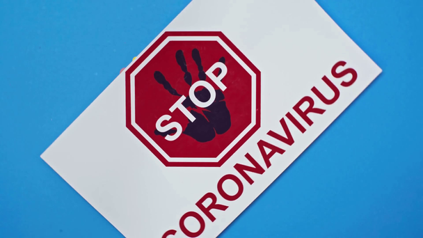 Vista superior de la tarjeta giratoria con letras stop coronavirus sobre fondo azul
 - Imágenes, Vídeo