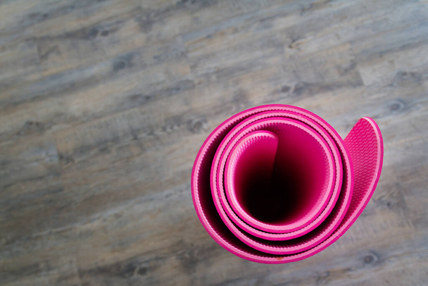 Фото циновки для йоги розового цвета находится внутри комнаты
. - Фото, изображение