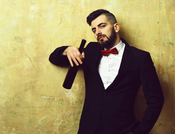 Man with stylish beard in suite holds bottle of wine - Foto, Imagem