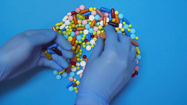 Draufsicht des Arztes, der Pillen von der sich drehenden blauen Oberfläche nimmt - Filmmaterial, Video