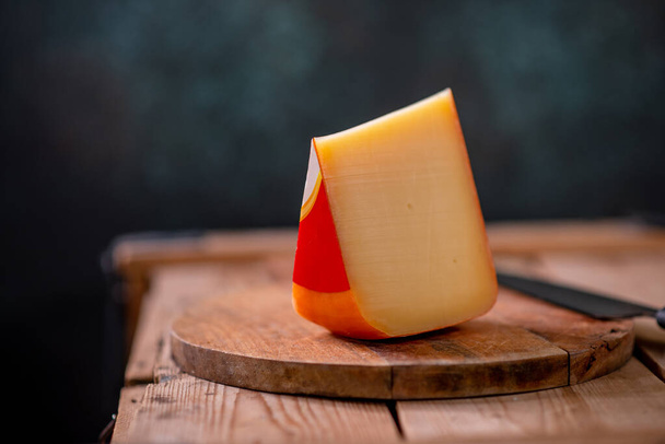 Hard cheese parmesan on wooden board on sunlight table traditional table texture side view - 写真・画像