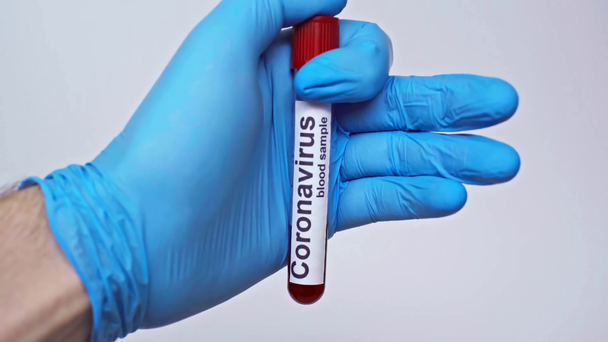 bijgesneden beeld van arts die coronavirus reageerbuis geïsoleerd op grijs houdt - Video