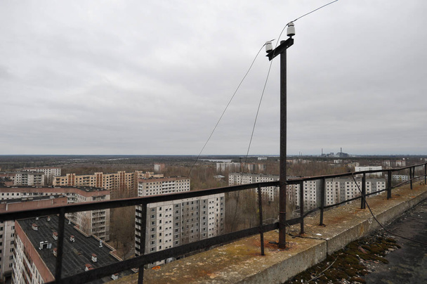 Dach w opuszczonym mieście widmo Prypeć, widok na elektrownię jądrową, post apokaliptyczne miasto, sezon wiosenny w strefie wykluczenia Czarnobyla, Ukraina - Zdjęcie, obraz