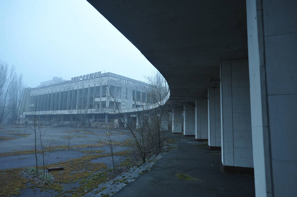 Terk edilmiş hayalet kasaba Pripyat 'ta Kültür Evi. Kıyamet sonrası şehir. Çernobil Yasaklama Bölgesi, Ukrayna' da bahar mevsimi. Rusça yazı: "Kültür Enerjisi Sarayı" - Fotoğraf, Görsel