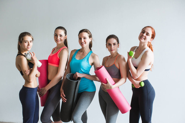 Happy group sporty woman with yoga mats standing. Female in gym after workout. - Fotografie, Obrázek
