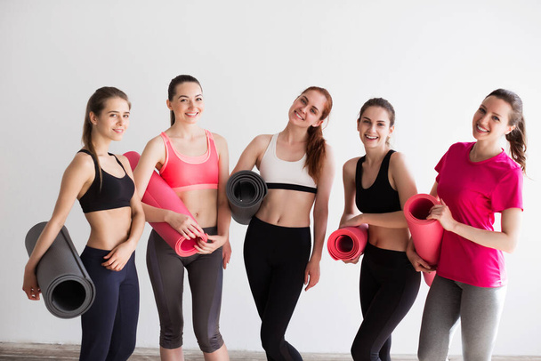 Group sporty woman with yoga mats standing. Female in gym after workout. - Foto, Imagem