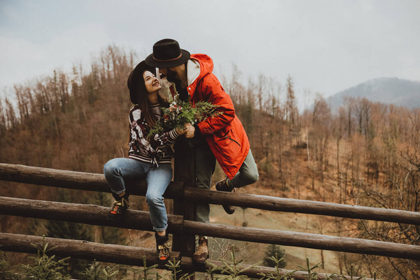 Loving couple walking on the mountain outdoors. Man and woman travel together. Couple traveler enjoys nature, hugs, - 写真・画像