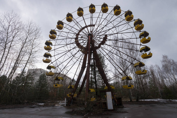 Ferris wheel in abandoned amusement park ghost town Pripyat, post apocalyptic city, spring season in Chernobyl exclusion zone, Ukraine - Fotoğraf, Görsel