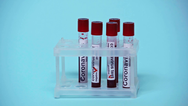 cropped view of doctor taking test tubes with coronavirus lettering on blue  - Footage, Video