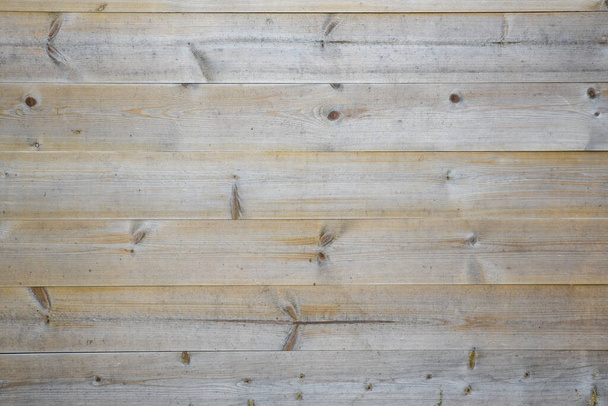 закрыть вид на деревянные доски, образующие забор. Узлы и зерно хорошо видны.
. - Фото, изображение