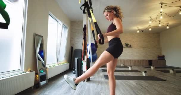 Un rendimiento equipado estudio señora practicando un TRX correas para estirar todo el cuerpo y hacer que el músculo tiene un concepto de estilo de vida saludable
. - Imágenes, Vídeo