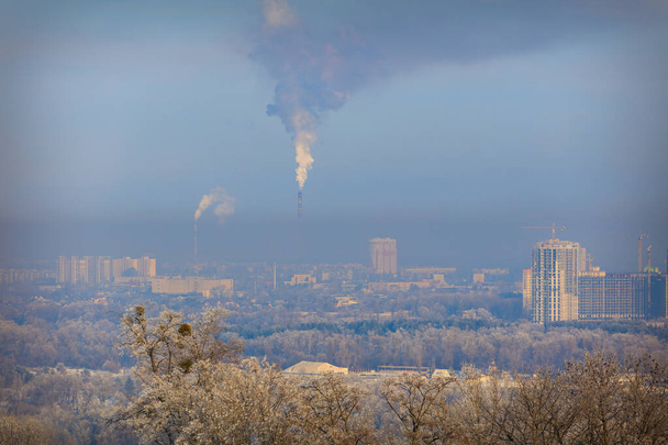 Fabriken verschmutzen die Luft. Smog in der Stadt. Frost auf den Bäumen. Winter. Die Menschen sterben an schmutziger Luft. CO2-Emissionen. Schlechte Luftqualität. Luftverschmutzung. Rohrfabriken. - Foto, Bild
