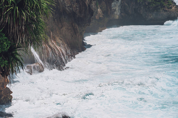 Photo of large waves crashing into large rocks on Nusa Penida island in Indonesia - Φωτογραφία, εικόνα