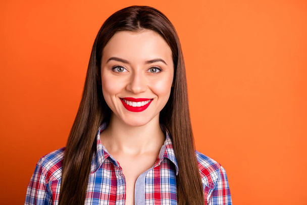 Closeup photo of attractive lady good mood bright red pomade toothy white smile long straight hairdo wear casual plaid shirt isolated vibrant orange color background - Zdjęcie, obraz